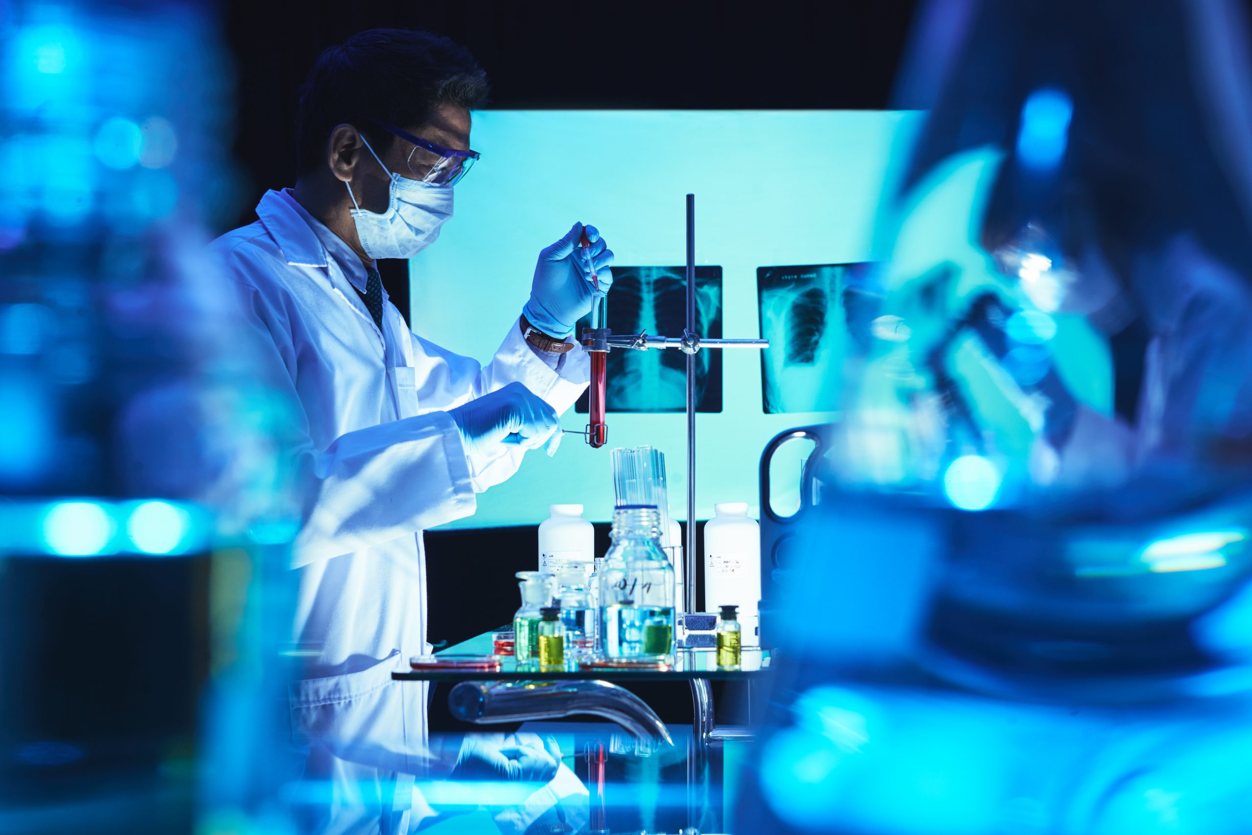 Chemist adding reagent in test-tube